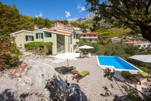 eine Villa mit einem Pool und einem Haus in der Unterkunft Villa Stina in Baška Voda