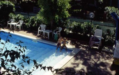 two people are playing in a swimming pool at La Coccinella Residence in San Vincenzo