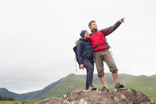 a man and a woman standing on top of a rock at Wild Atlantic Hostel in Leenaun