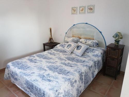 een slaapkamer met een blauw en wit bed met kussens bij VILLA LES NACRES A 400 MT DAL MARE in Porto-Vecchio