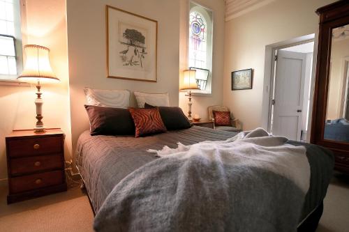 a bedroom with a bed and two lamps and a window at A Tassie Church in Kempton