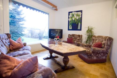 uma sala de estar com uma mesa e cadeiras e uma televisão em Zimmer Weiss em Altenstadt