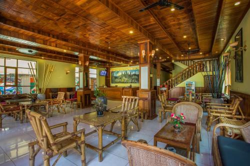 a restaurant with tables and chairs and a staircase at Side Walk Hotel in Siem Reap