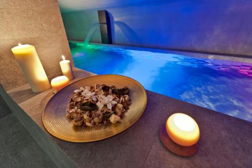 a plate of food on a table next to a swimming pool at Hotel Fado Spa & Restaurant in Świdnica