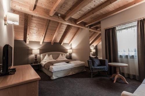 ein Schlafzimmer mit einem Bett und einem TV in einem Zimmer in der Unterkunft Hotel Garni Villa Park in St. Ulrich in Gröden