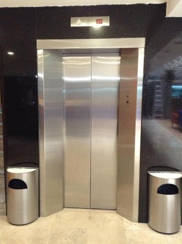 an elevator in a building with two trash at Hotel Azores in Mexico City