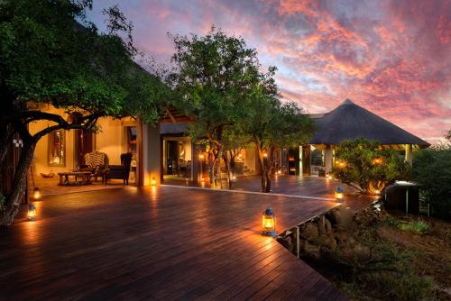 a wooden deck with lights on a house at Lush Private Game Lodge in Pilanesberg