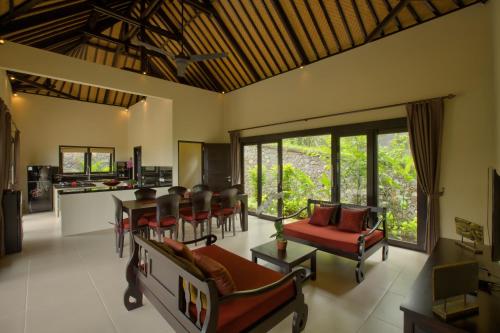 un soggiorno con mobili rossi e una cucina di VILLA CAHAYA Perfectly formed by the natural surrounding and Balinese hospitality a Lovina