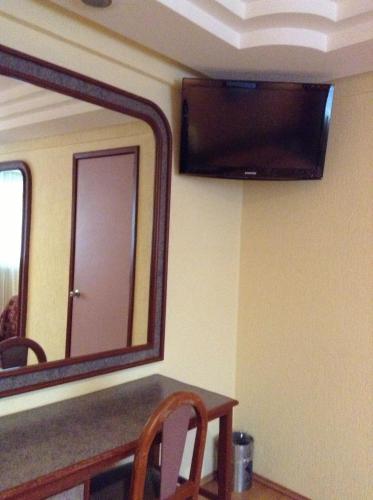 a mirror on the wall of a room with a table at Hotel Azores in Mexico City