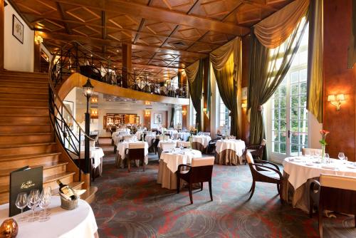 une salle à manger avec des tables et des chaises blanches dans l'établissement Chateau de Montvillargenne, à Gouvieux