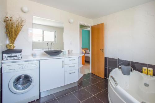a bathroom with a washing machine and a sink at Nissi Maria Villa in Ayia Napa