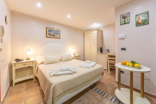 ピアノ・ディ・ソレントにあるB&B La Casa Nel Giardinoのベッドルーム1室(ベッド1台、フルーツ付きのテーブル付)