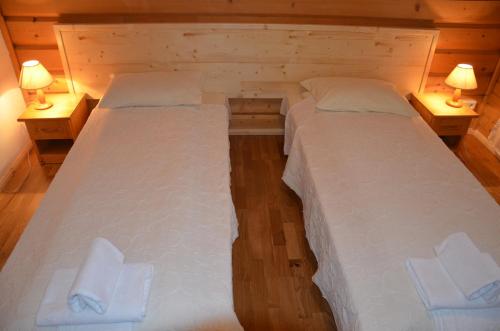 two beds in a small room with two lamps at Zajazd Beskidy in Żywiec