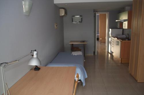 Habitación con cama y mesa con lámpara. en Apartaments Turístics Residencia Vila Nova, en Vilanova i la Geltrú