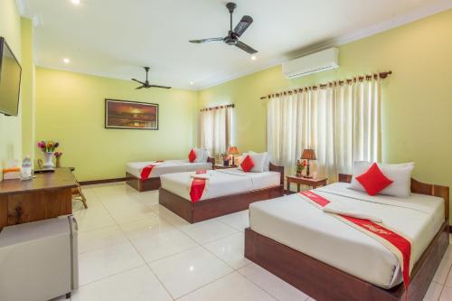 a hotel room with two beds and a television at Side Walk Hotel in Siem Reap