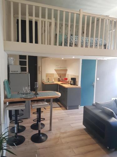 un salon avec une table et une cuisine dans l'établissement Studio Du Marche, à Dinan