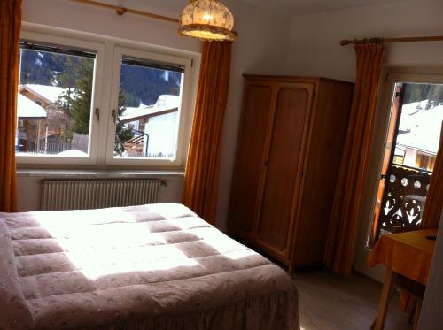 a bedroom with a bed and a large window at Garnì Villa Cecilia in Mazzin