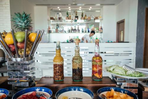 een tafel met flessen alcohol en borden met eten bij Acron Waterfront Resort in Baga