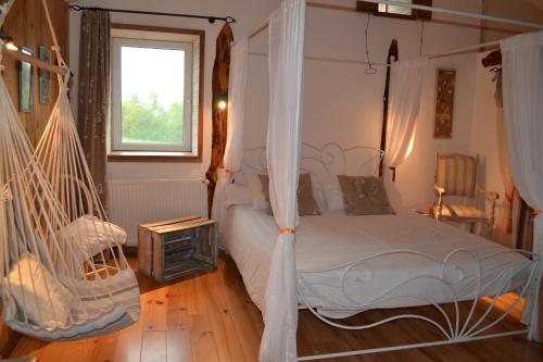 a bedroom with a hammock bed and a window at Le Jardin des Pierres Brunes in Saint-Jean-des-Ollières