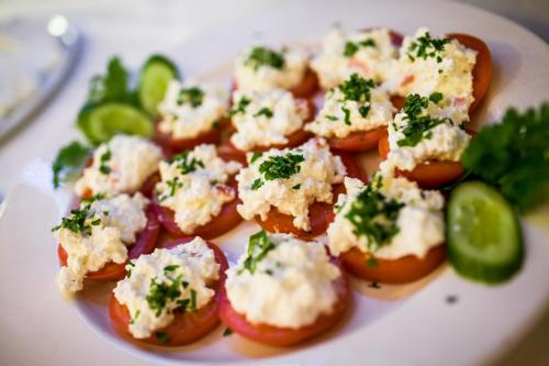 a plate of food with tomatoes and cheese and vegetables at Ośrodek Wypoczynkowy Eden Kąty Rybackie in Kąty Rybackie