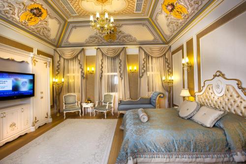 a bedroom with a king sized bed and a television at Limak Thermal Boutique Hotel in Gokcedere