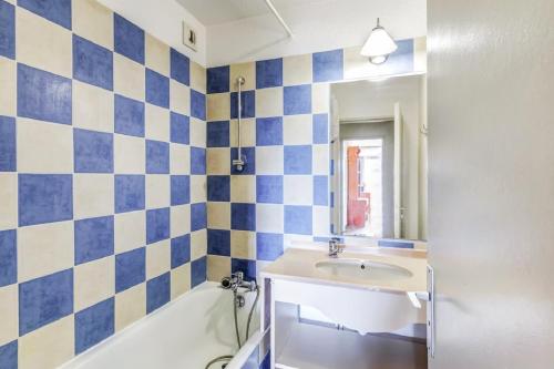 La salle de bains est pourvue de carrelage bleu et blanc. dans l'établissement Residence Hyeres Parc - maeva Home, à Hyères
