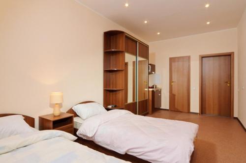 a bedroom with two beds and a table with a lamp at Lukyanovsky in Kyiv