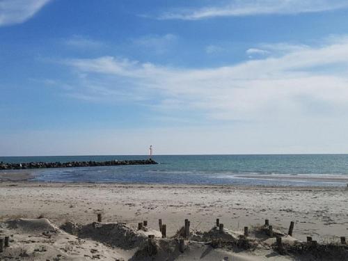 a sand castle on the beach with a lighthouse in the ocean at Ferienhaus Familie Mischkies in Damp