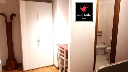 a bathroom with a white closet with a sign on it at Casa Lady in Garda