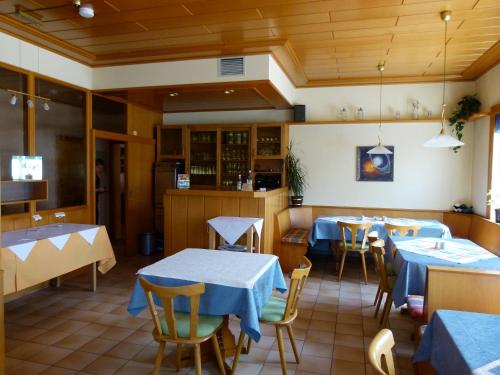 a restaurant with tables and chairs in a room at Pension "Zum Schwan" in Muhr amSee