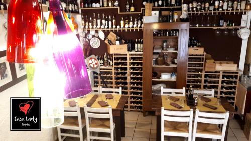 a room with a table and chairs and a bottle of wine at Casa Lady in Garda