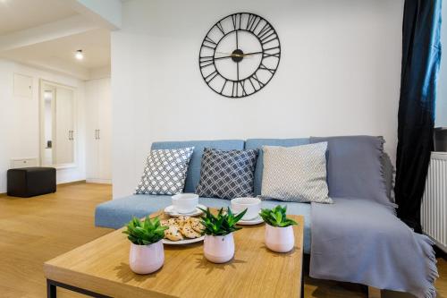 a living room with a blue couch and a clock at Rent like home - Droga na Bystre in Zakopane