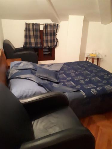 a bedroom with a bed and a chair at Apartment Biba in Virpazar