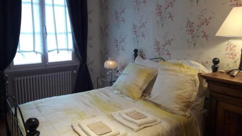 a bedroom with a bed with white sheets and pillows at La Vigne Vierge in Châteauneuf-sur-Loire