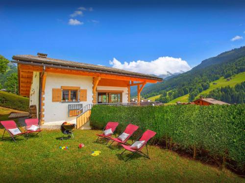 a group of chairs sitting in the grass in front of a house at Chalet Alyssum - OVO Network in Le Grand-Bornand