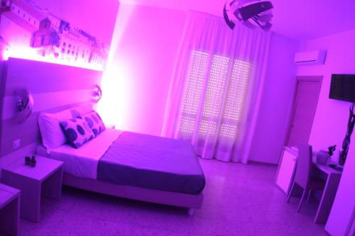 a purple bedroom with a bed and a table at A'MANTIA HOTEL in Amantea