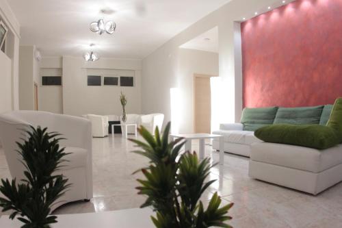 a living room with white furniture and a red wall at A'MANTIA HOTEL in Amantea