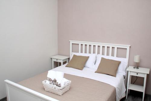 a bedroom with a white bed with a basket on it at B&B Materdei 14 in Naples
