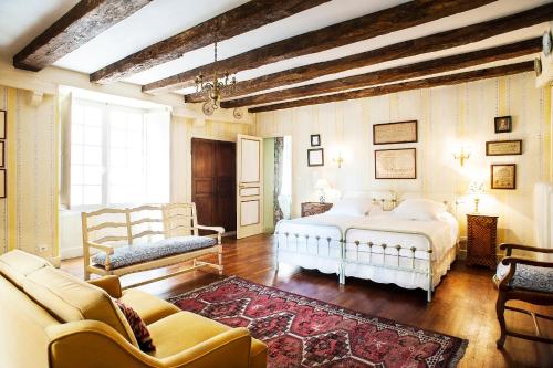 une chambre avec un lit, un canapé et une chaise dans l'établissement Appartements Les Suites sarladaises, à Sarlat-la-Canéda