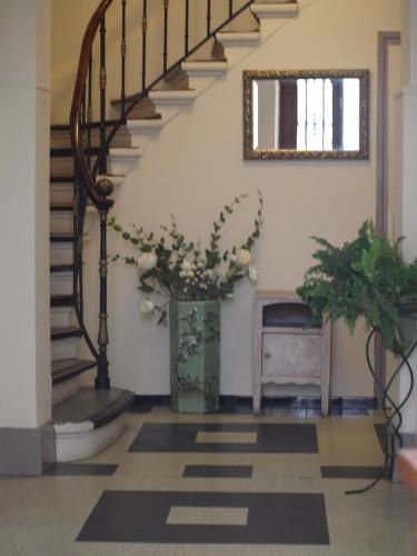 a hallway with stairs and a vase of flowers at Hôtel des Facultés in Lyon