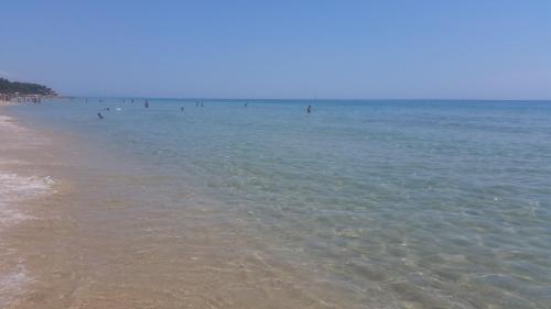 a group of people in the water at the beach at Villa Eden Home Holiday in Santa Margherita di Pula