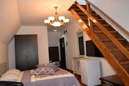 ein Schlafzimmer mit einem Bett und einer Holztreppe in der Unterkunft Hanu Satului in Constanţa
