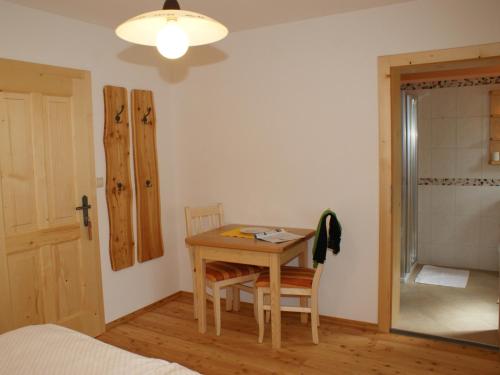 a bedroom with a table and chairs and a bed at Biobauernhof Nussbaumer in Nussdorf am Attersee