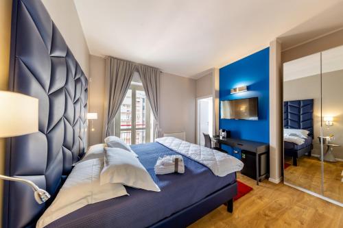 a blue bedroom with a bed and a television at Album Boutique Rooms in Sassari