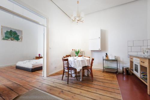 cocina y comedor con mesa y cama en 3 Bedroom Apartment (ACELI) en Berlín