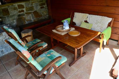 einen Holztisch und Stühle auf einer Terrasse in der Unterkunft Apartments Ve Dvoře in Mosty u Jablunkova