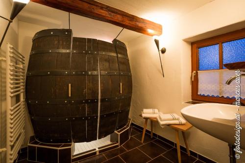 a bathroom with a large barrel on the wall at Streuobsthof Weissenbacher in Kindberg