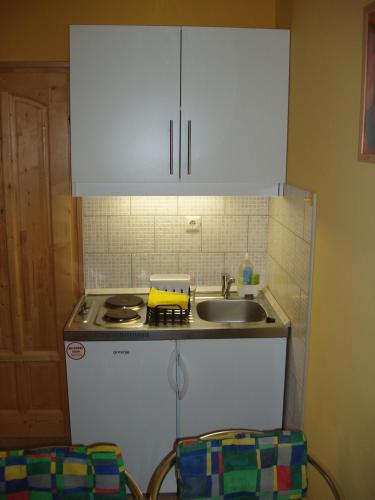 a kitchen with white cabinets and a sink at Franciska Portája in Igal