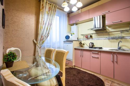 ムィコラーイウにある2-komnatnaia kvartira v tsentreのピンクのキャビネットとガラスのテーブル付きのキッチンが備わります。