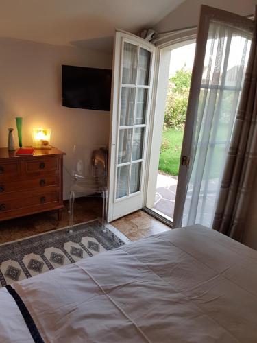 Schlafzimmer mit einem Bett und einer Glasschiebetür in der Unterkunft Maison Luvy in Sundhoffen